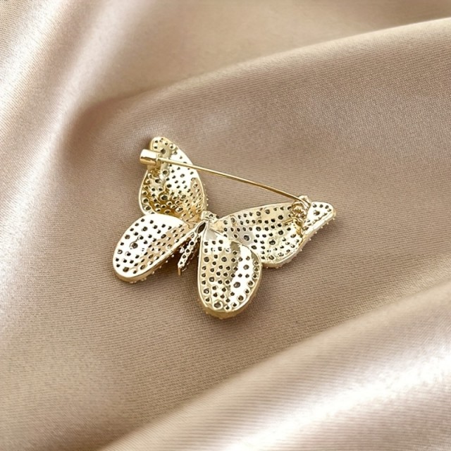 Elegantna zlata broška z metuljčkom