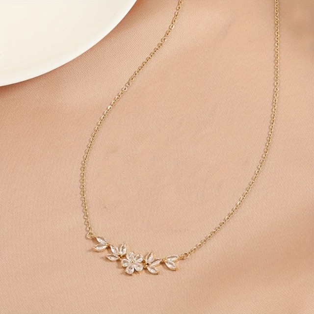 Elegantna minimalistična ogrlica z listnim in cvetličnim obeskom