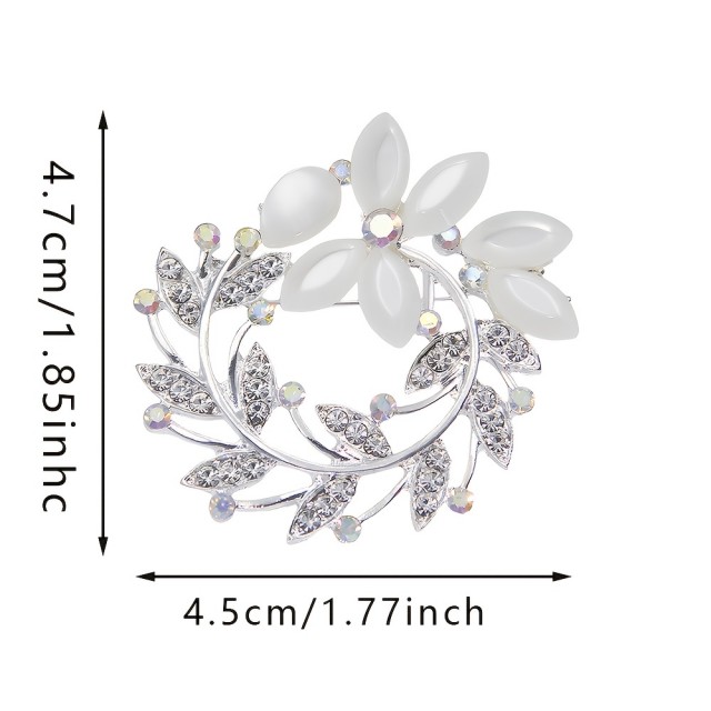 Elegantna broška z okrasnimi kamni v obliki venca