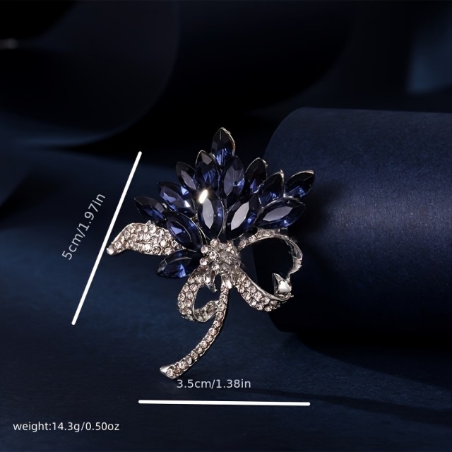 Elegantna broška z modrimi dragulji
