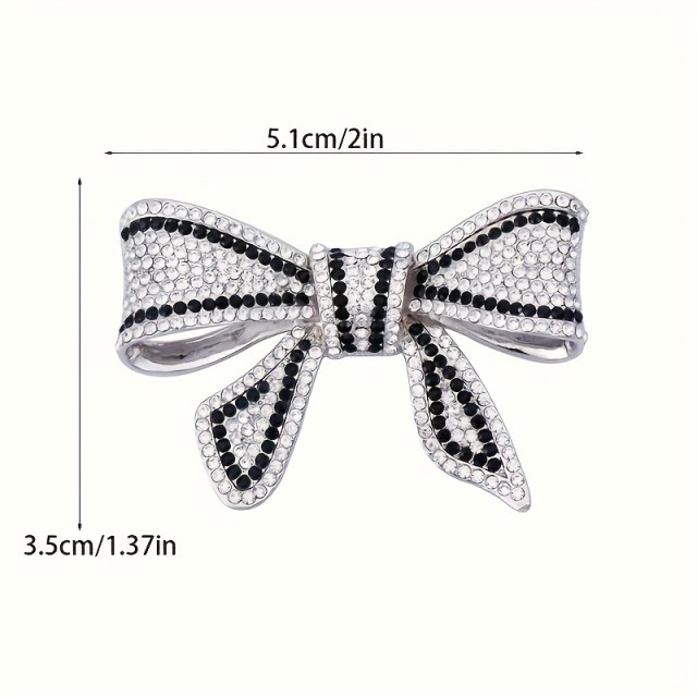 Elegantna broška z okrasnimi kamni v obliki pentlje 