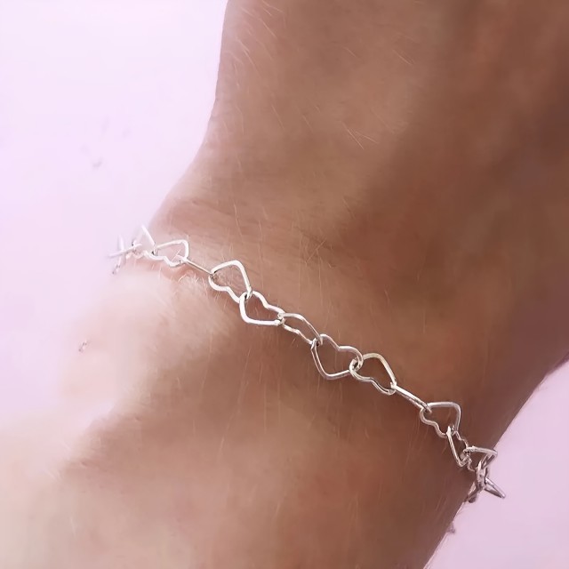 Elegantna zapestnica srebrne barve z izrezljanimi srci