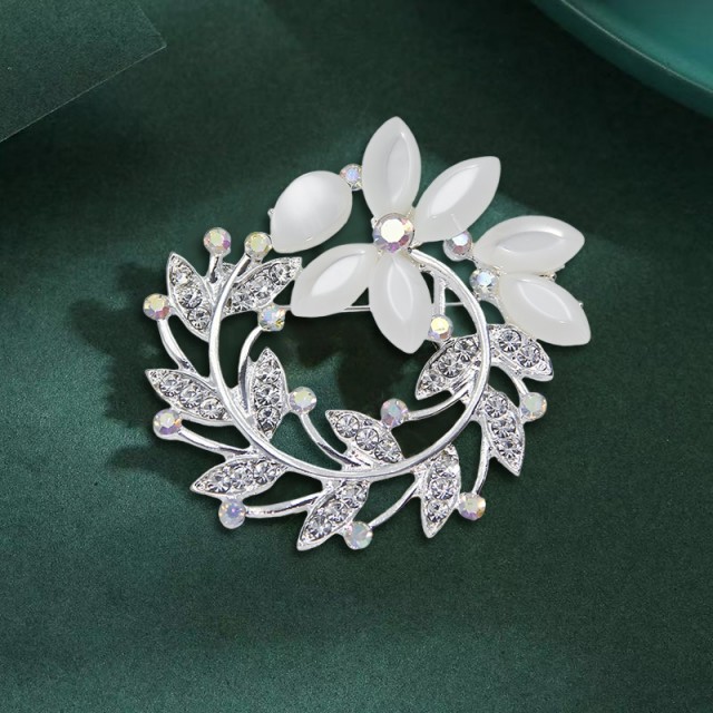 Elegantna broška z okrasnimi kamni v obliki venca