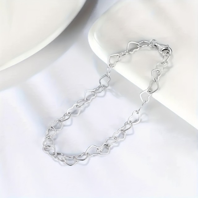 Elegantna zapestnica srebrne barve z izrezljanimi srci