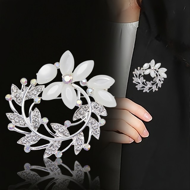 Elegantna broška z okrasnimi kamni v obliki venca