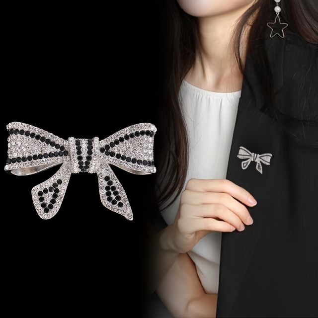 Elegantna broška z okrasnimi kamni v obliki pentlje 