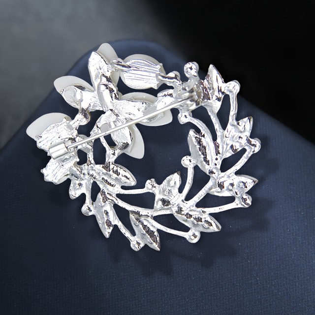 Elegantna broška z okrasnimi kamni v obliki venca