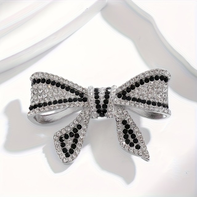 Elegantna broška z okrasnimi kamni v obliki pentlje 