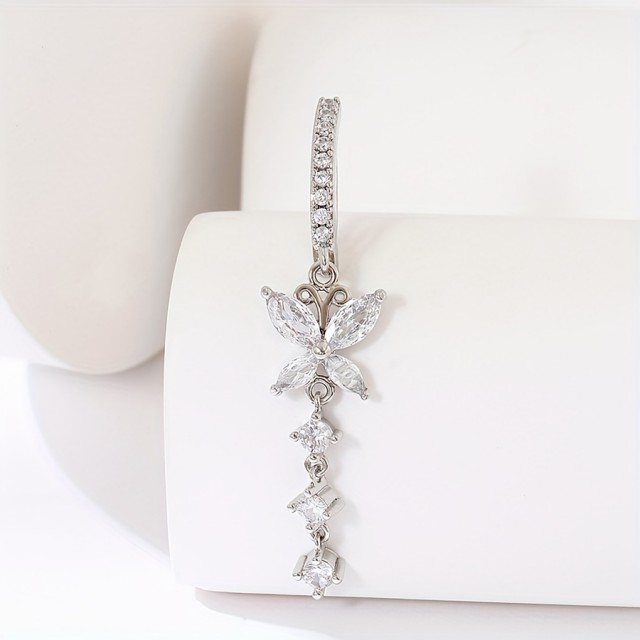 Piercing z metuljčkom in visečimi kamenčki