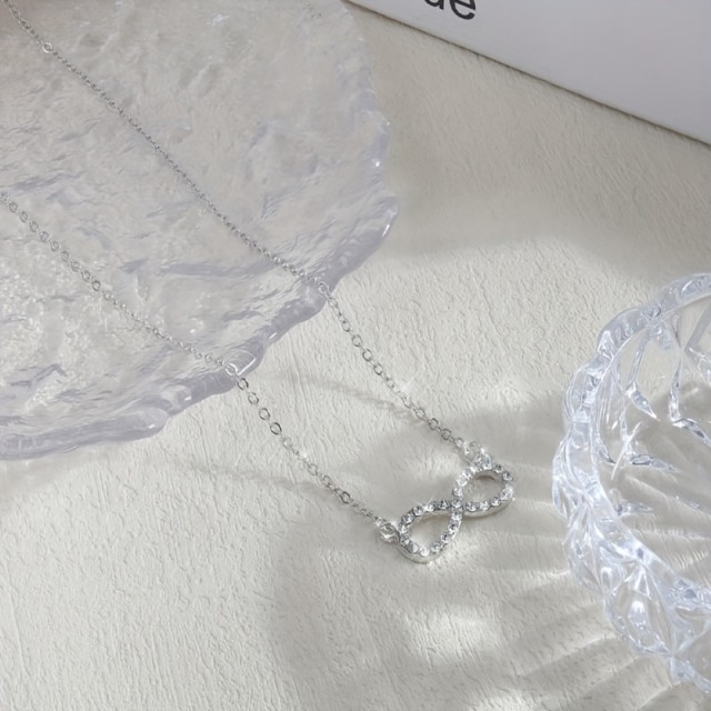 Elegantna ogrlica z znakom neskončnosti v srebrni barvi
