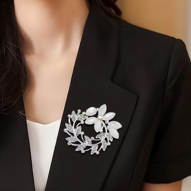 Elegantna broška z okrasnimi kamni v obliki venca