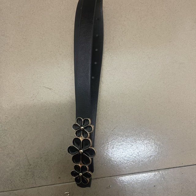 Eleganten črn pas z okrasnimi cvetličnimi detajli