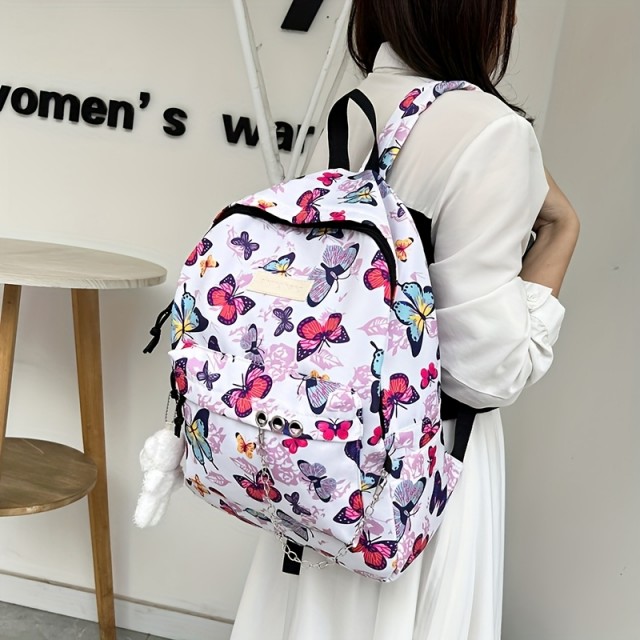 Moden nahrbtnik z barvitimi metulji in obeskom medvedka