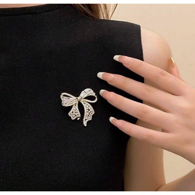 Elegantna zlata broška v obliki pentlje