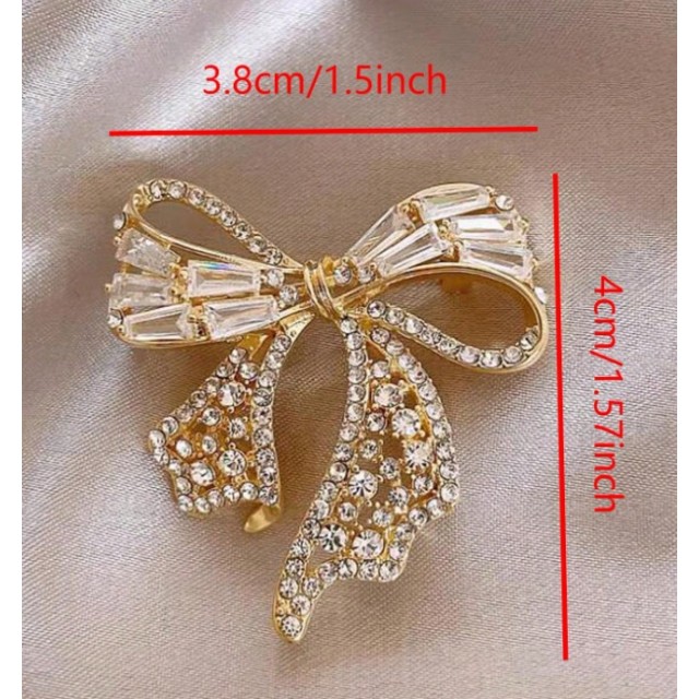 Elegantna zlata broška v obliki pentlje