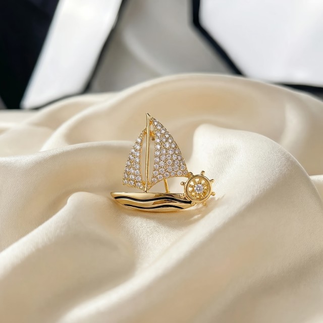 Elegantna broška z ladjico zlate barve