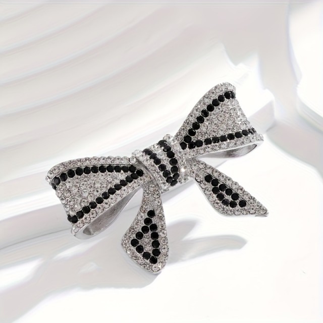 Elegantna broška z okrasnimi kamni v obliki pentlje 