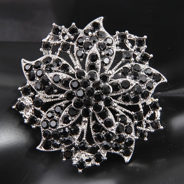 Elegantna cvetlična broška z bleščečimi črnimi kamni 