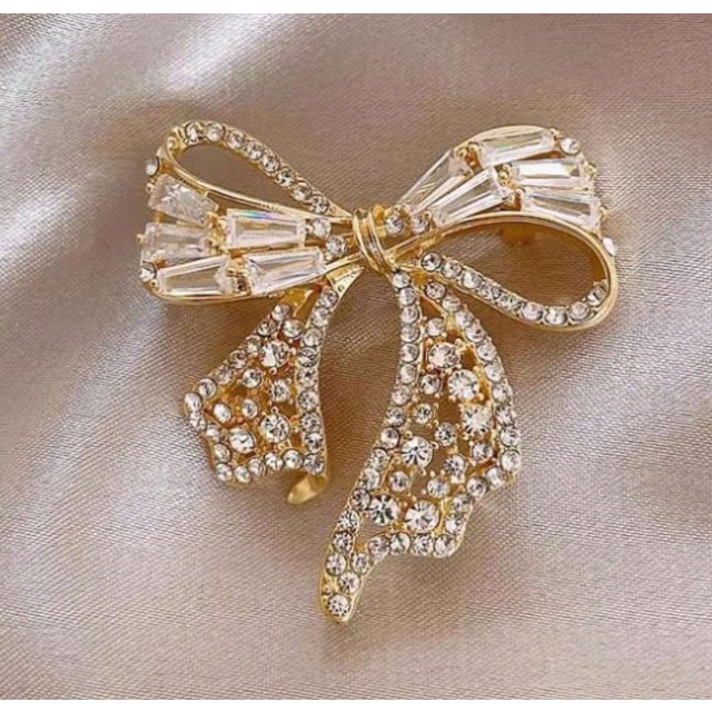 Elegantna zlata broška v obliki pentlje